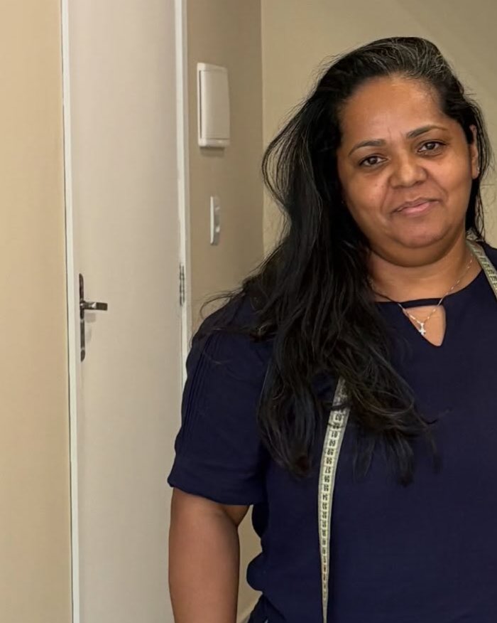 Marise Lucas, fundadora do Vértice Ateliê, com fita métrica no ateliê